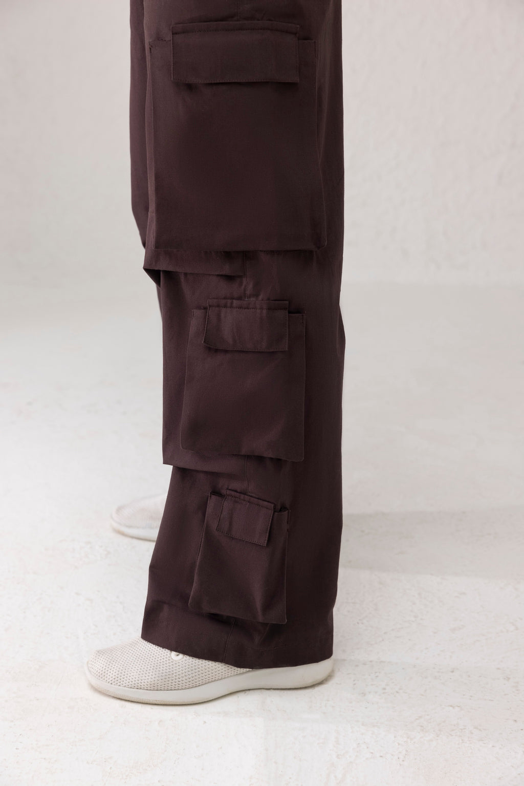 Close-up of side funnel pockets and twill texture on coffee brown cargo pants
