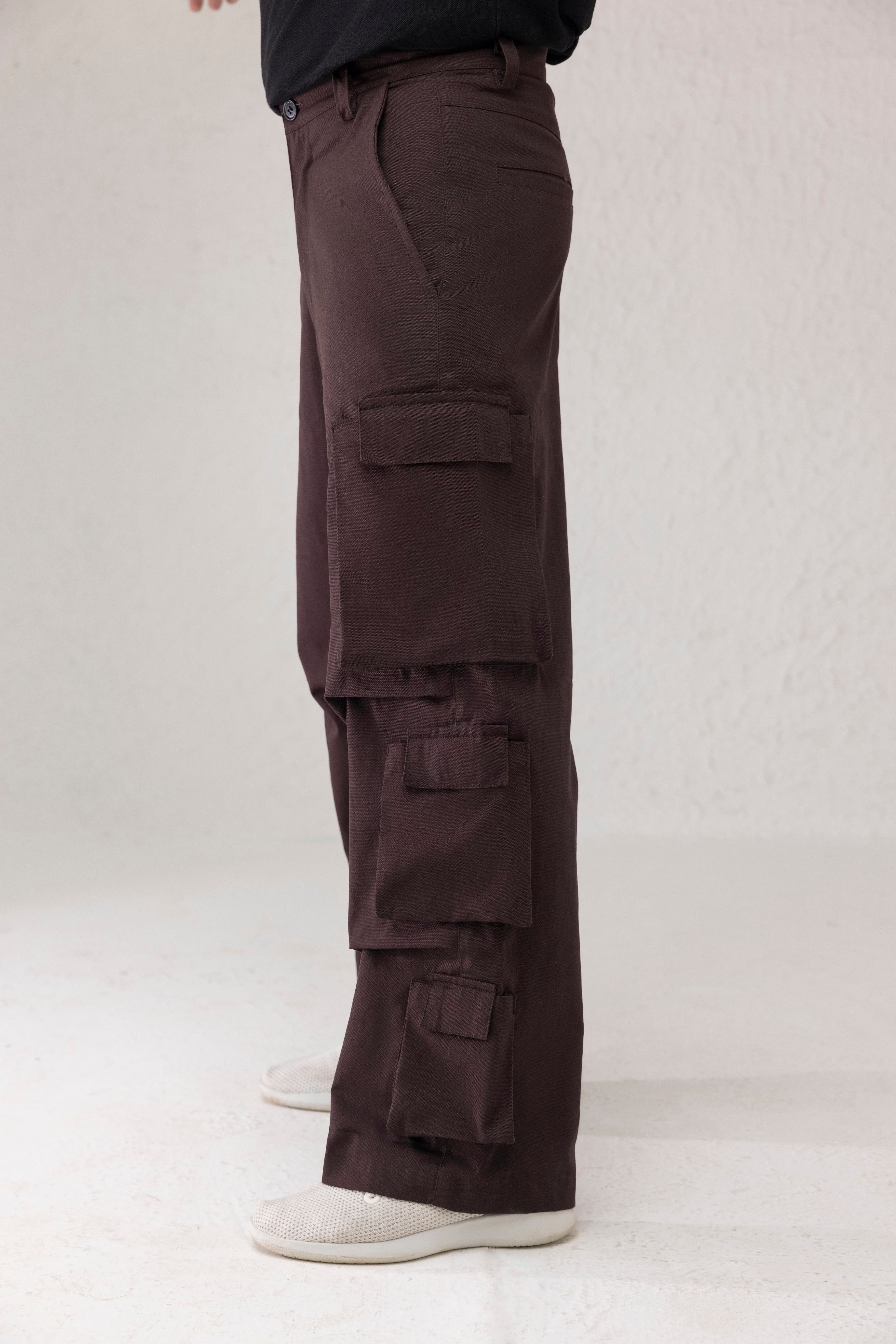 Side profile showing six funnel style side pockets on wide leg cargo pants in dark coffee brown