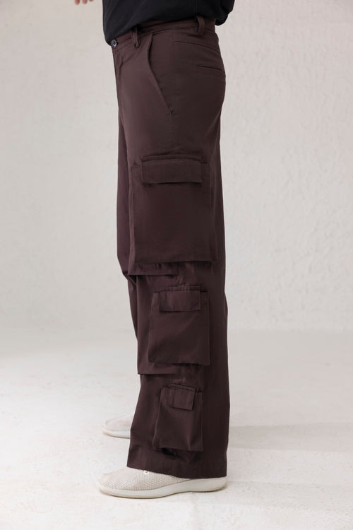 Side profile showing six funnel style side pockets on wide leg cargo pants in dark coffee brown