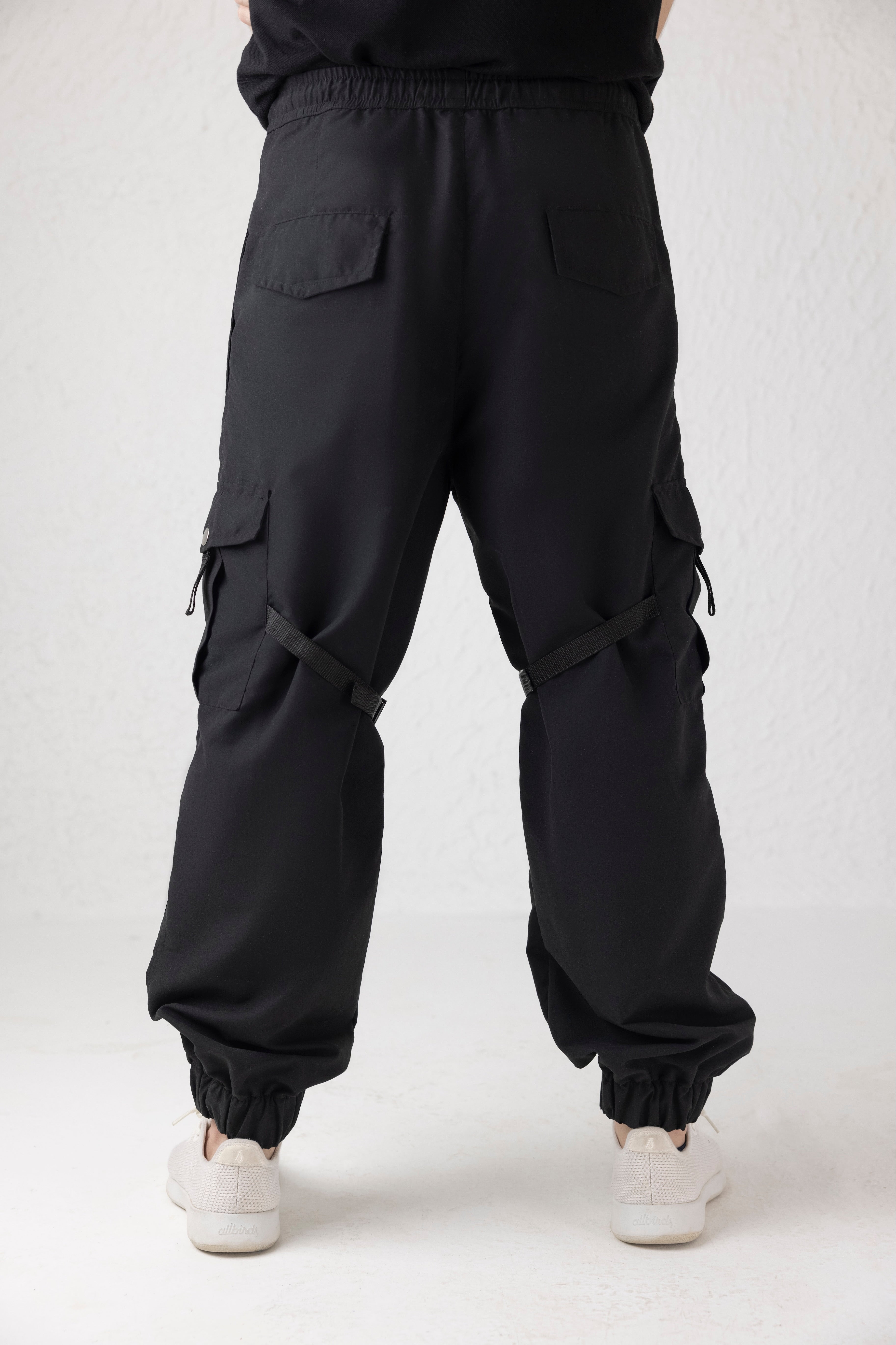 Rear profile of black Nyxbound cargo pants with elasticated hem and secure fit