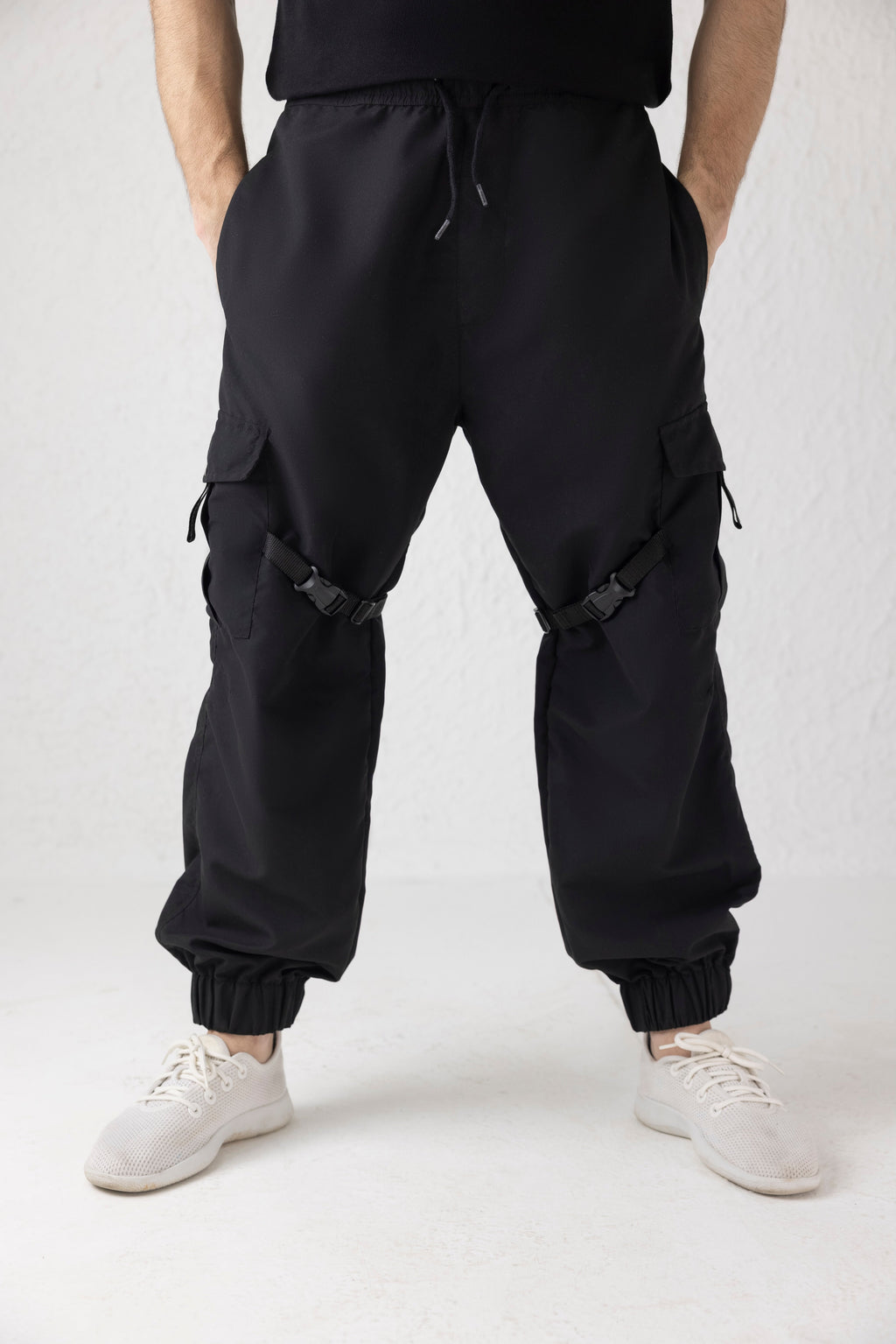 Front view of Nyxbound Strap Utility Cargo Pants in black with elastic waist and clean athletic design