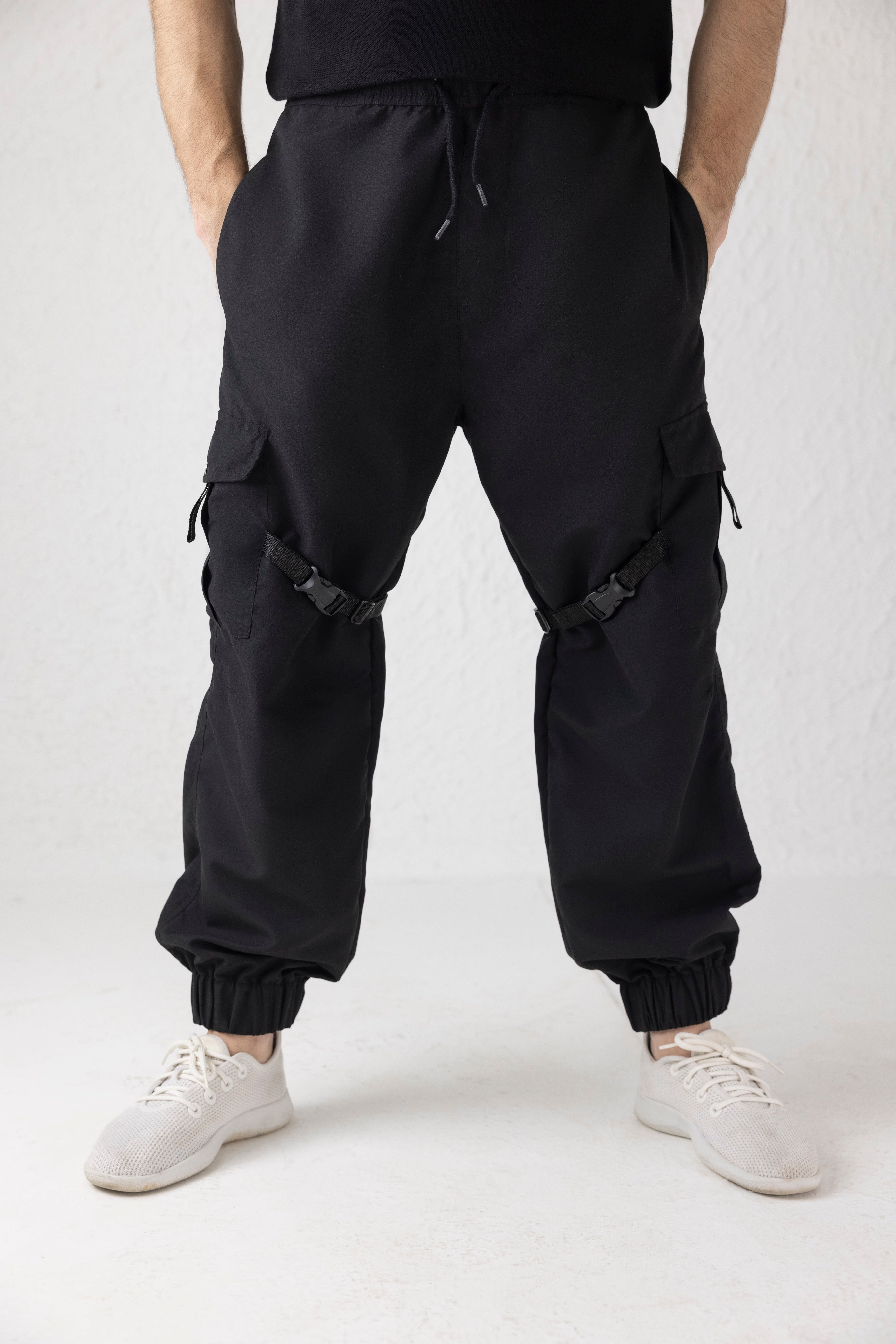 Front view of Nyxbound Strap Utility Cargo Pants in black with elastic waist and clean athletic design
