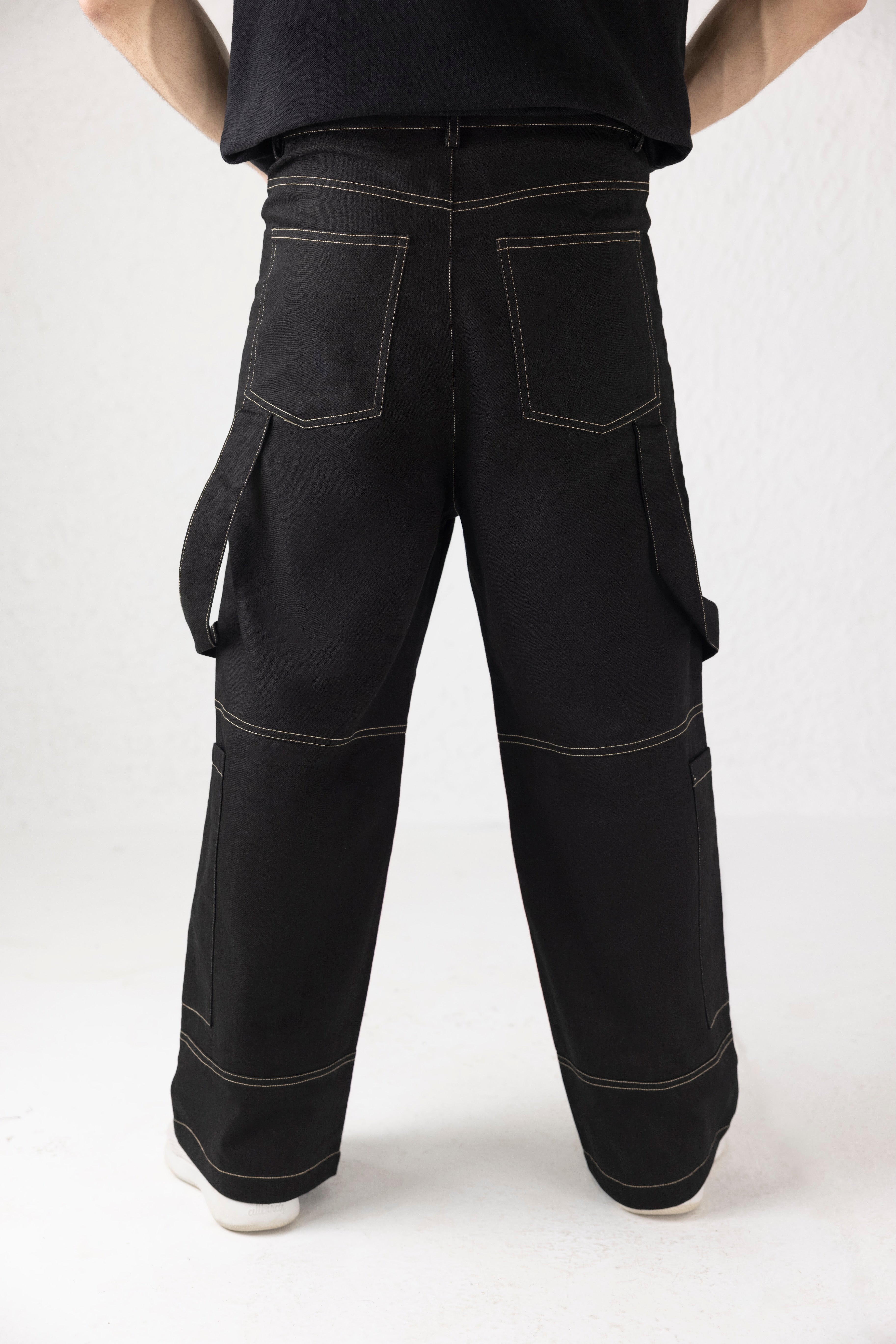 Back profile of black Onyxdrop denim cargo pants with contrast stitching and tapered fit