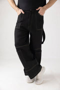 Close-up of light brown stitching and vertically belted side thigh detail on black denim cargo pants
