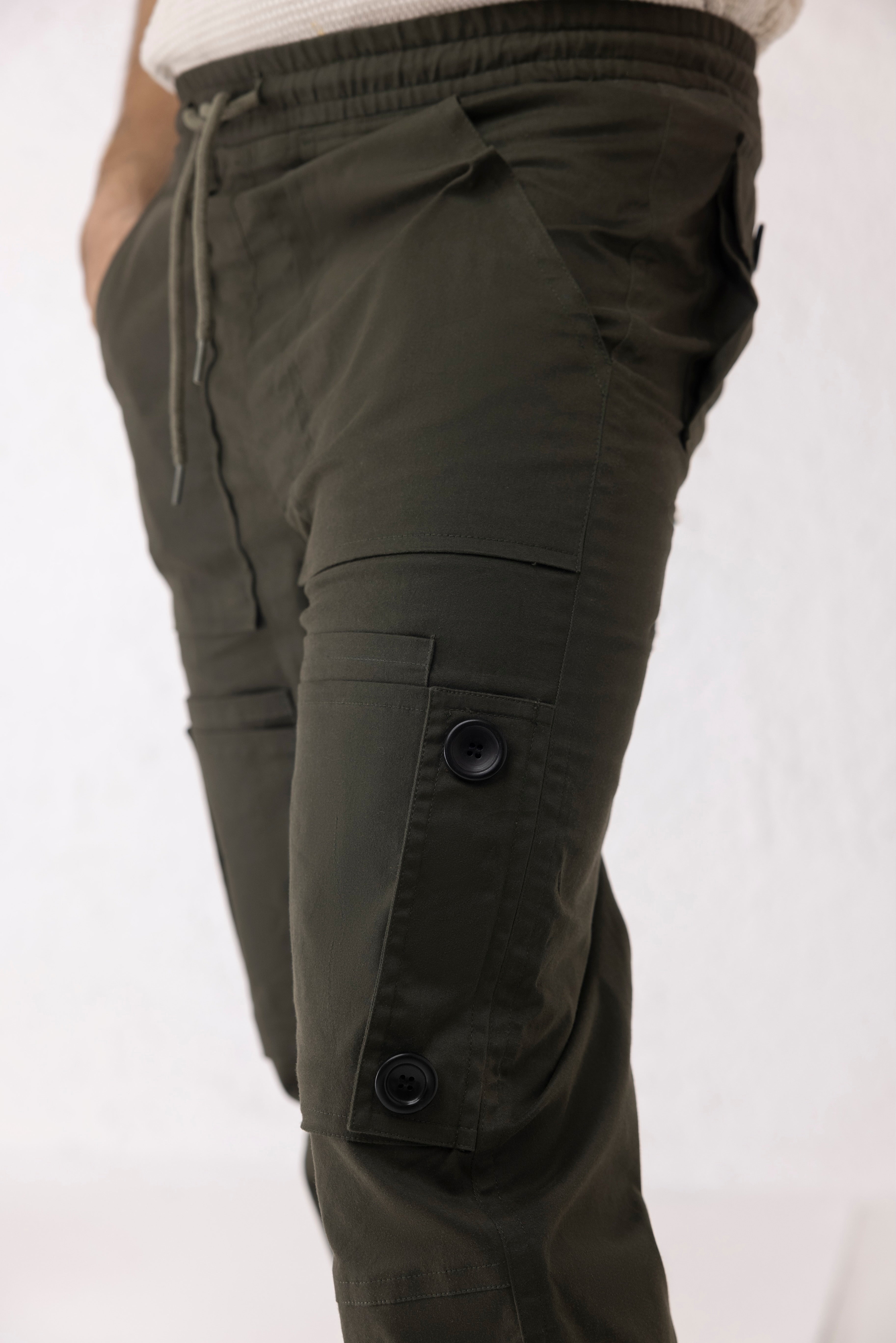 Close-up of black buttons and elastic hem on olive green twill cargo pants – Thyron by Decuir